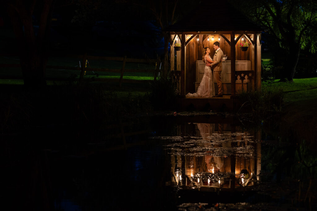 Bride and groom at night by lake