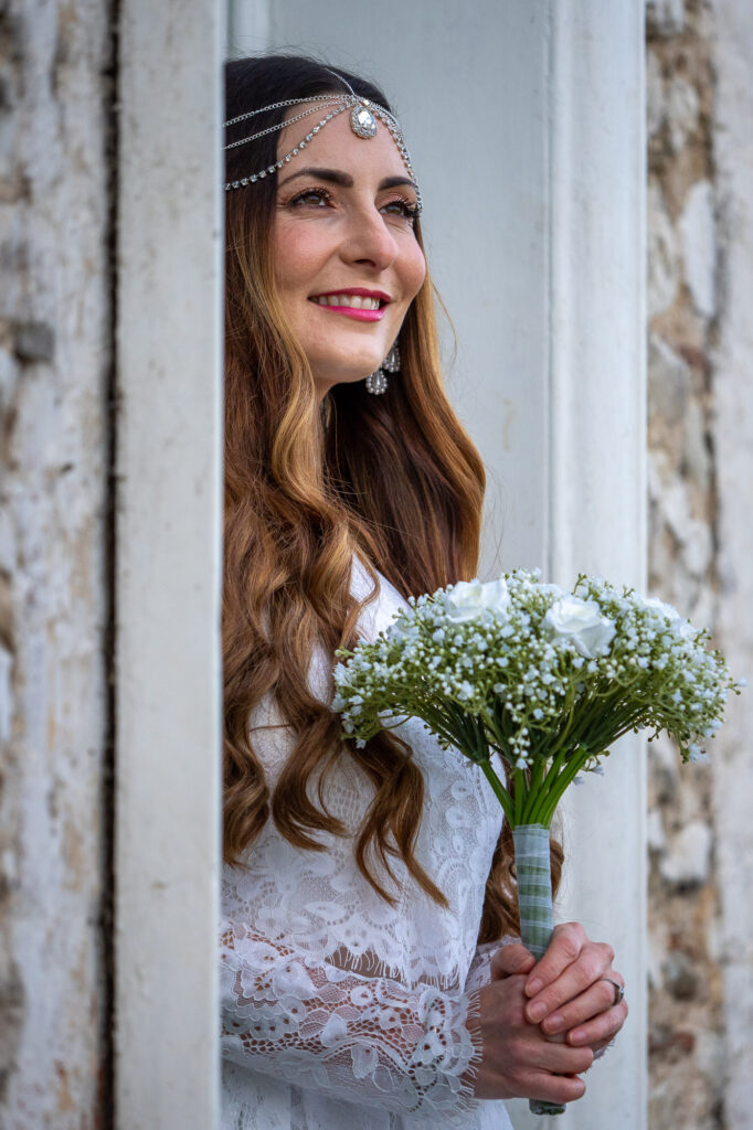 Bride with flowers standing in doorway